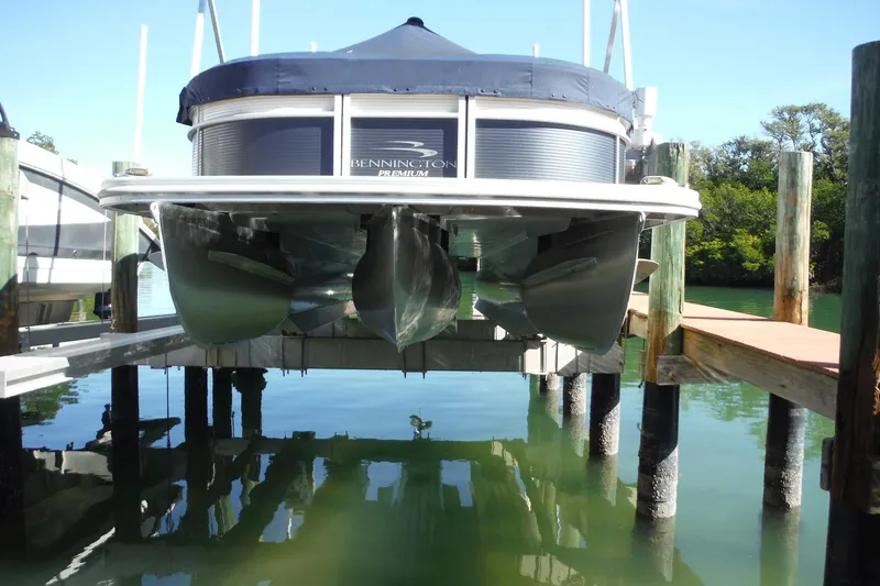 Slide: The Image of 2019 Bennington SX 22 SSRX pontoon boat docked on a lift over calm water. - 32