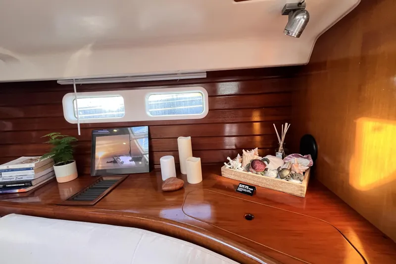 Slide: The Image of Interior of 2001 Beneteau 473 yacht with decor, books, and seashells on wooden surface. - 12