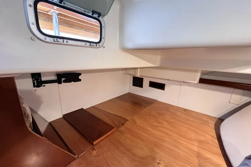 Slide: The Image of Interior cabin of 2001 Beneteau 473 sailboat with wooden flooring and porthole window. - 22