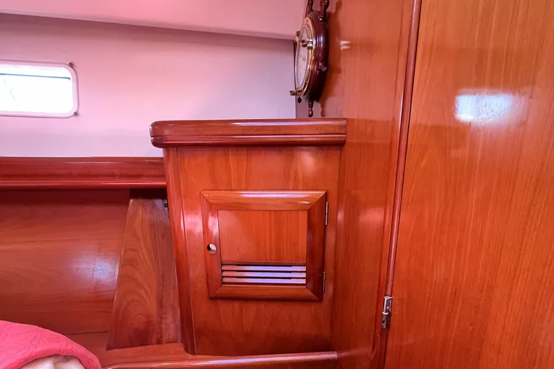 Slide: The Image of Interior of 2001 Beneteau 473 sailboat with polished wooden cabinetry and nautical decor. - 27