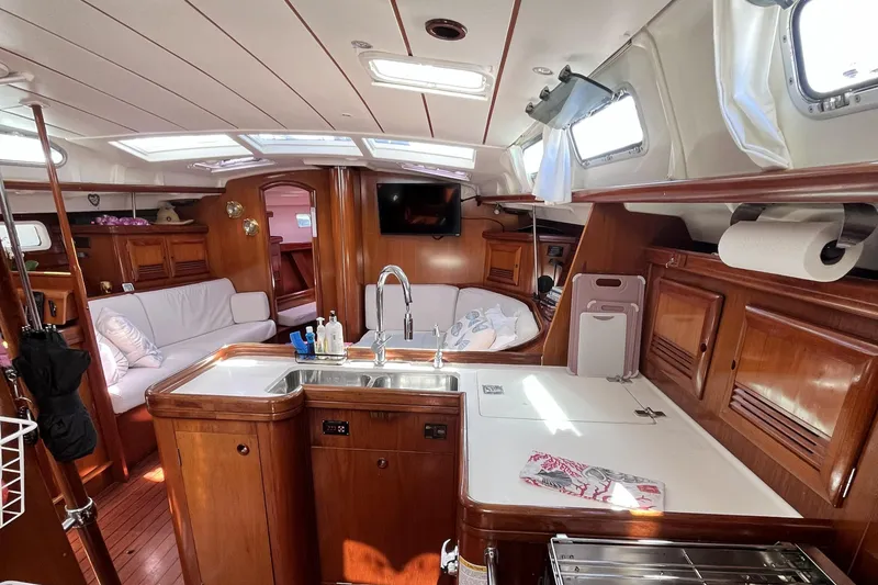 Slide: The Image of Luxurious interior of a 2001 Beneteau 473 sailboat with wood finishes and modern amenities. - 30