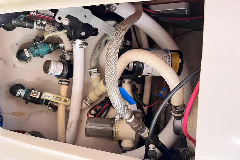 Slide: The Image of Plumbing system inside a 2001 Beneteau 473 yacht, featuring hoses and valves. - 43
