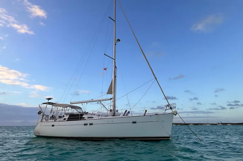 Slide: The Image of Sailing yacht Beneteau 473, 2001 model, anchored on calm ocean waters at sunset. - 44