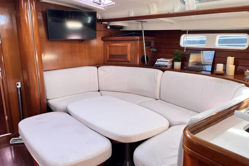 Slide: The Image of Luxurious interior of 2001 Beneteau 473 yacht with white seating and wooden accents. - 6