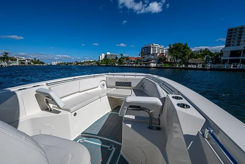 Slide: The Image of 2021 Cobia 320 Center Console boat on scenic waterfront with clear blue sky. - 1