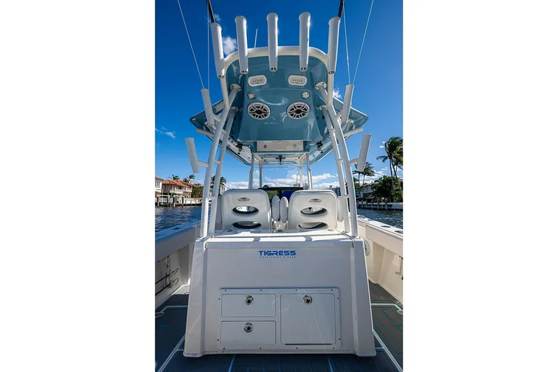 Slide: The Image of 2021 Cobia 320 Center Console boat with T-top and rod holders on a sunny day. - 10