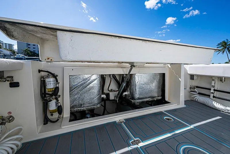 Slide: The Image of 2021 Cobia 320 Center Console boat with open storage compartment, blue sky background. - 11