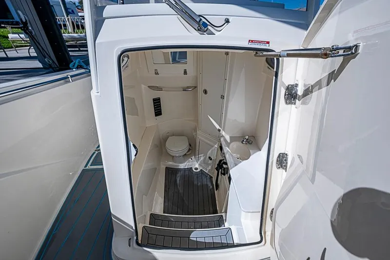 Slide: The Image of 2021 Cobia 320 Center Console boat interior with compact bathroom amenities. - 16