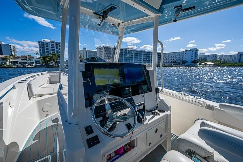 Slide: The Image of 2021 Cobia 320 Center Console boat interior with modern dashboard on a sunny day. - 20