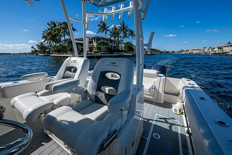 Slide: The Image of 2021 Cobia 320 Center Console boat on scenic waterfront with palm trees. - 21