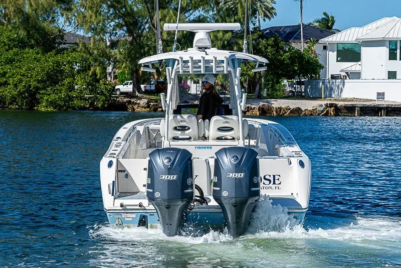 Slide: The Image of 2021 Cobia 320 Center Console boat cruising on water with dual Yamaha engines. - 28