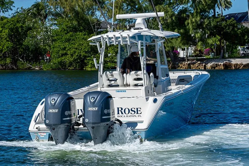 Slide: The Image of 2021 Cobia 320 Center Console boat cruising on water with twin Yamaha engines. - 29