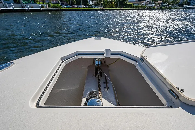 Slide: The Image of 2021 Cobia 320 Center Console boat anchor compartment on a sunny day. - 3