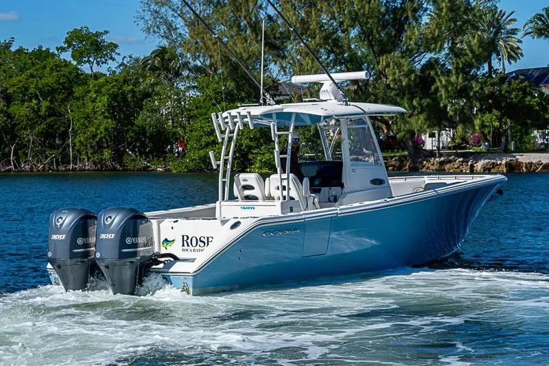 Slide: The Image of 2021 Cobia 320 Center Console boat cruising on a scenic waterway. - 30