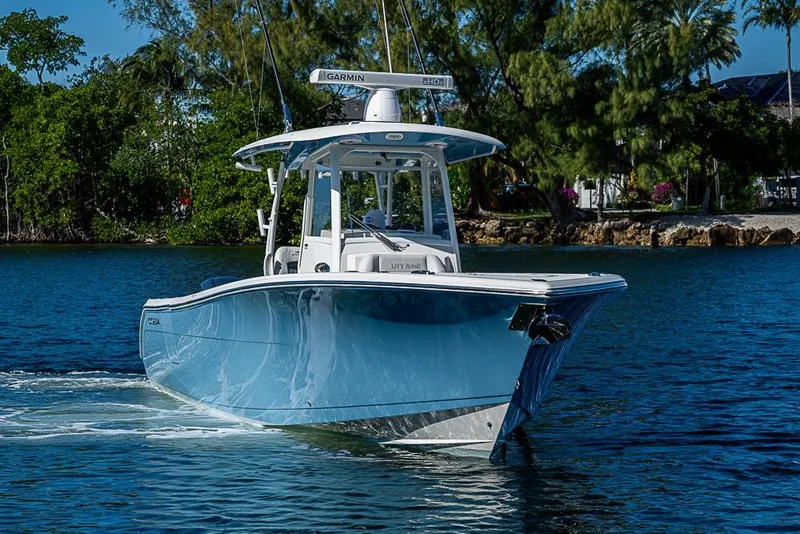 Slide: The Image of 2021 Cobia 320 Center Console boat cruising on a scenic waterway. - 34
