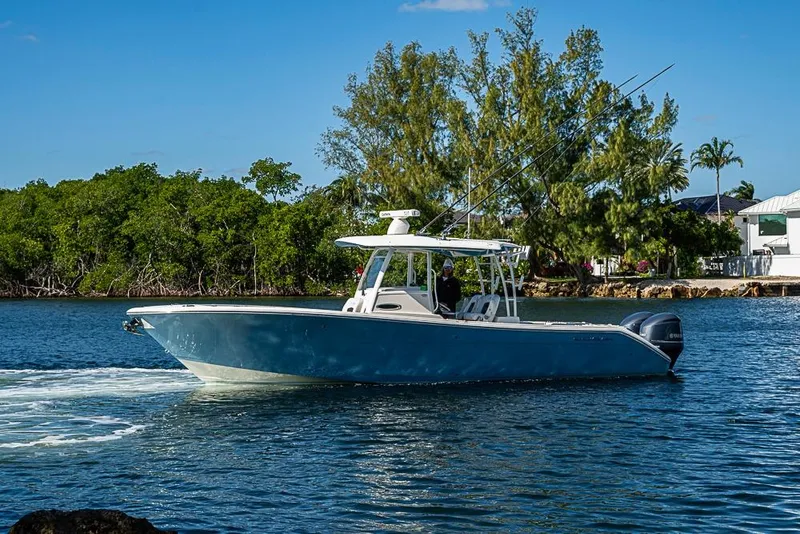 Slide: The Image of 2021 Cobia 320 Center Console boat cruising on a scenic waterway. - 36