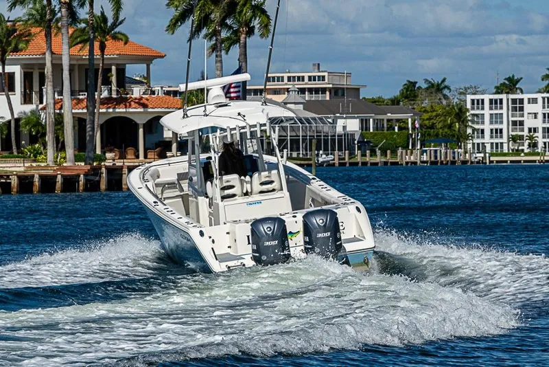 Slide: The Image of 2021 Cobia 320 Center Console boat cruising on a sunny waterfront. - 40
