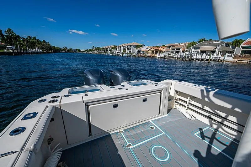 Slide: The Image of 2021 Cobia 320 Center Console boat on a scenic waterfront with clear blue skies. - 6