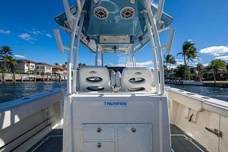 Slide: The Image of 2021 Cobia 320 Center Console boat on water, sunny day, palm trees in background. - 9