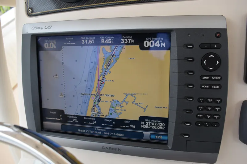 Slide: The Image of 2012 Grady-White Canyon 271 boat storage compartment with hose and open lid. - 20