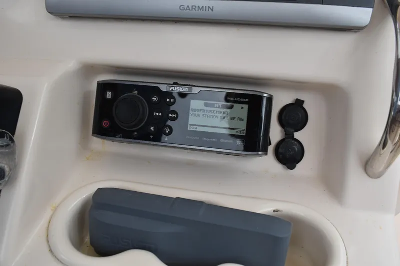 Slide: The Image of 2012 Grady-White Canyon 271 boat interior with cushioned seating and storage compartment. - 22