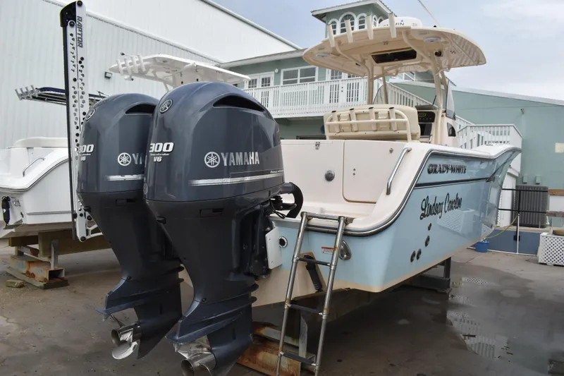 Slide: The Image of 2012 Grady-White Canyon 271 boat on display at a marina under a blue sky. - 3