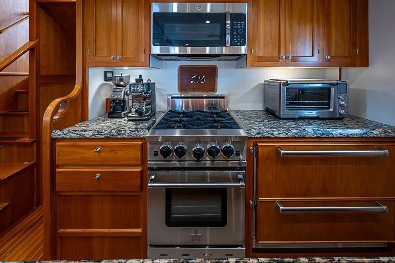 Slide: The Image of Luxurious 2016 Kadey-Krogen 52 yacht kitchen with stainless steel appliances and wooden cabinetry. - 13