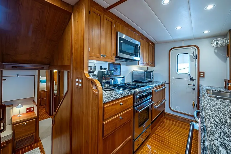 Slide: The Image of Luxurious 2016 Kadey-Krogen 52 yacht kitchen with wood cabinetry and modern appliances. - 14