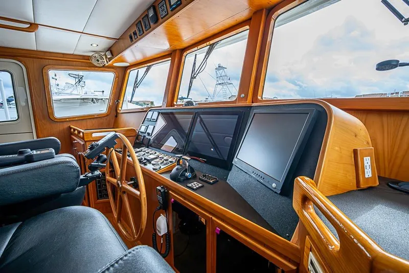 Slide: The Image of Pilothouse of 2016 Kadey-Krogen 52 yacht with modern navigation equipment and wooden interior. - 22
