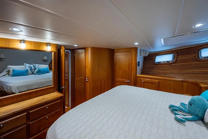 Slide: The Image of Luxurious 2016 Kadey-Krogen 52 yacht bedroom with wood accents and plush bedding. - 27