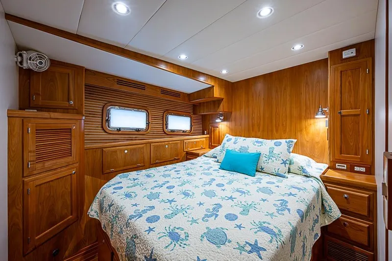 Slide: The Image of Luxurious 2016 Kadey-Krogen 52 yacht bedroom with wood paneling and nautical-themed bedding. - 32