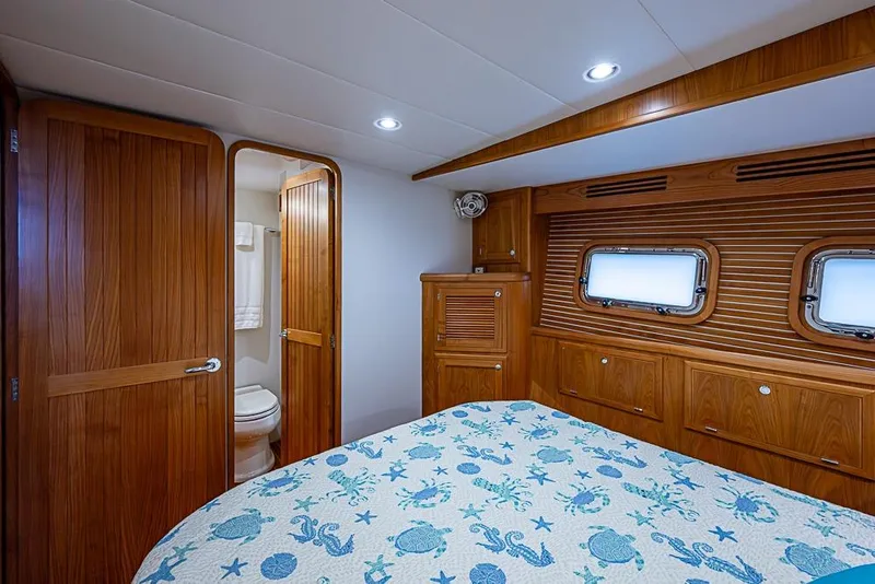 Slide: The Image of Luxurious 2016 Kadey-Krogen 52 yacht cabin with wooden interior and nautical-themed bedding. - 35