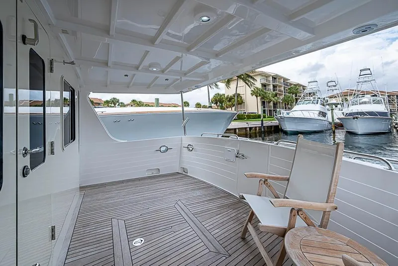 Slide: The Image of 2016 Kadey-Krogen 52 yacht deck with wooden chairs, marina view. - 46