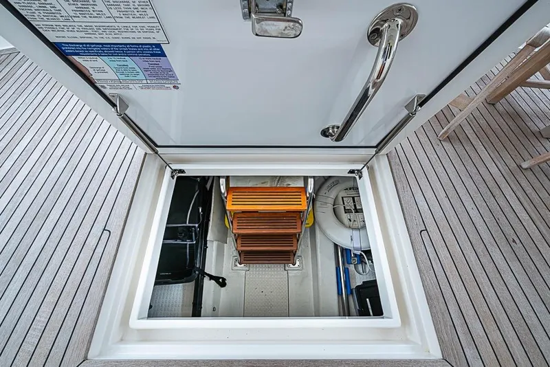 Slide: The Image of Open hatch on 2016 Kadey-Krogen 52 yacht, revealing wooden steps and storage area. - 48