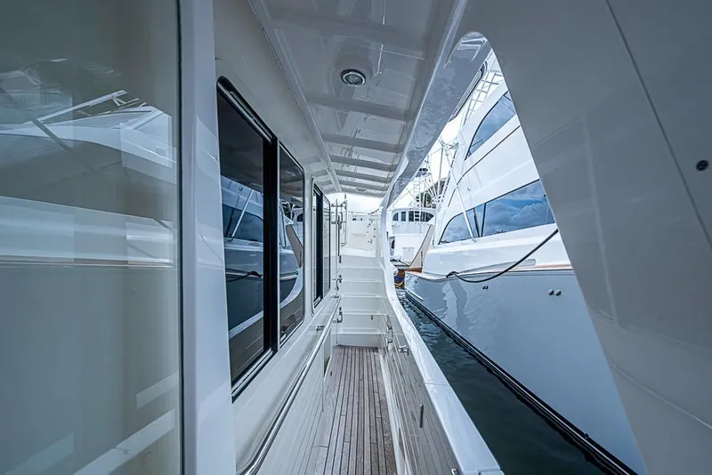 Slide: The Image of Side deck view of 2016 Kadey-Krogen 52 yacht, showcasing sleek design and marina setting. - 50