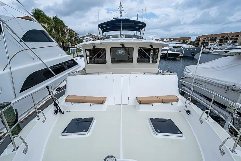 Slide: The Image of 2016 Kadey-Krogen 52 yacht docked at marina, featuring spacious deck and seating area. - 57