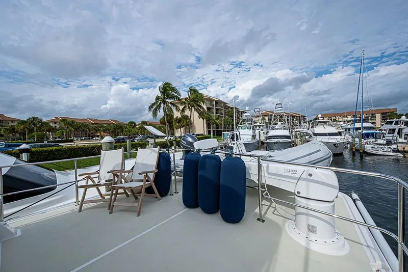 Slide: The Image of 2016 Kadey-Krogen 52 yacht deck with chairs, docked in a marina under cloudy skies. - 61