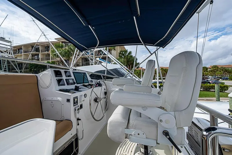 Slide: The Image of Helm of 2016 Kadey-Krogen 52 yacht with white seating and navigation controls. - 66