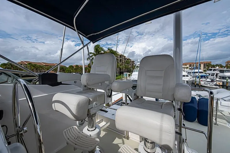 Slide: The Image of Flybridge seating on 2016 Kadey-Krogen 52 yacht, featuring two white captain's chairs. - 68