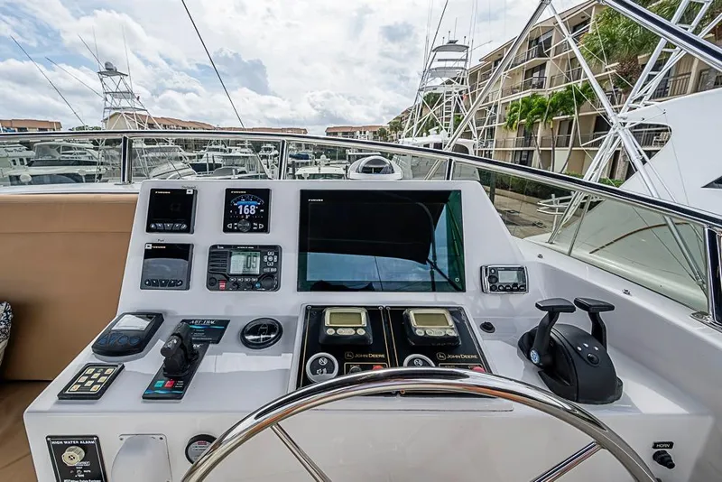 Slide: The Image of Cockpit view of 2016 Kadey-Krogen 52 yacht with advanced navigation controls and marina backdrop. - 69