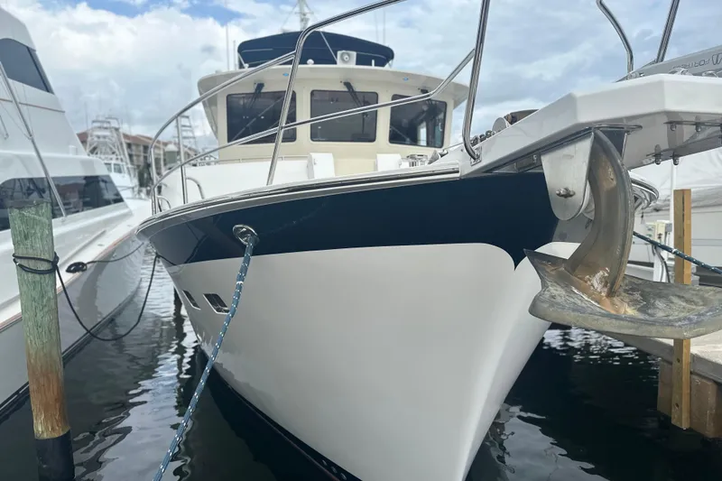 Slide: The Image of 2016 Kadey-Krogen 52 yacht docked, showcasing sleek design and anchor detail. - 94