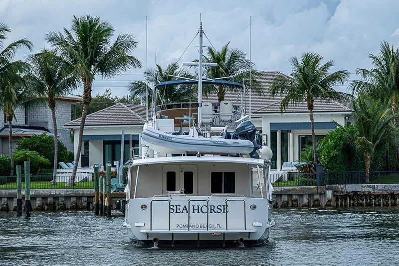 Slide: The Image of Kadey-Krogen 52 yacht, 2016 model, docked near a waterfront home with palm trees. - 2