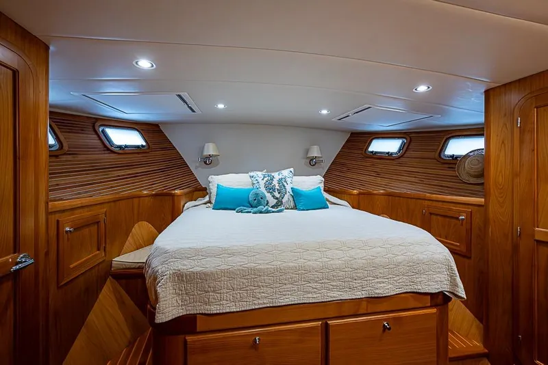Slide: The Image of Luxurious 2016 Kadey-Krogen 52 yacht bedroom with wood paneling and cozy bedding. - 25