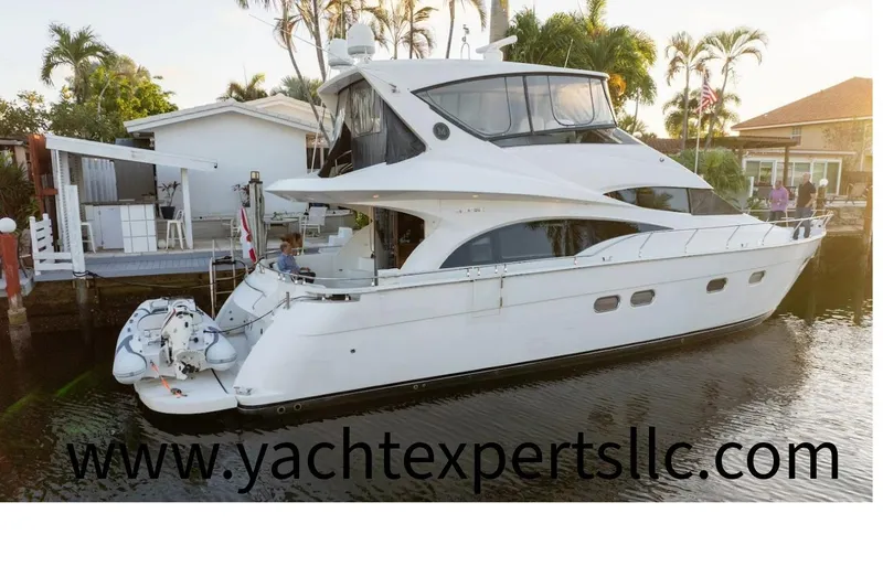 The Image of 2006 Marquis 59 yacht docked near waterfront homes with palm trees. - 0