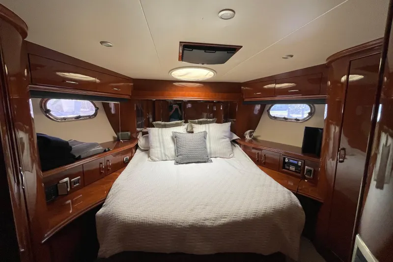 Slide: The Image of Luxurious 2006 Marquis 59 yacht bedroom with elegant wood finish and cozy bedding. - 11