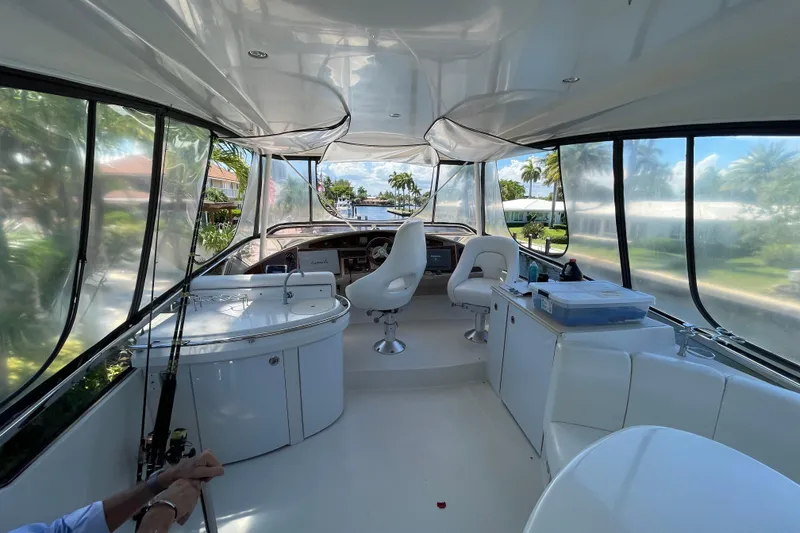 Slide: The Image of Luxurious interior of a 2006 Marquis 59 yacht with white seating and panoramic windows. - 21