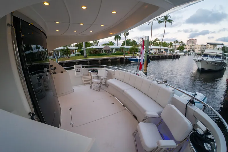 Slide: The Image of Luxurious 2006 Marquis 59 yacht deck with seating, docked by a scenic waterfront. - 3