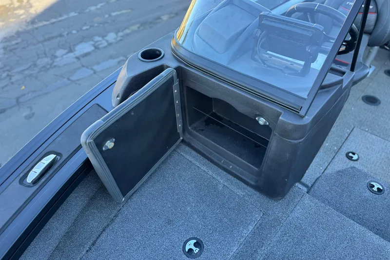 Slide: The Image of 2023 Tracker Targa V-19 WT boat interior with open storage compartment and windshield. - 13
