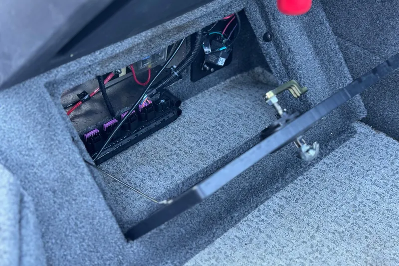 Slide: The Image of 2023 Tracker Targa V-19 WT boat interior wiring compartment with visible cables and components. - 29