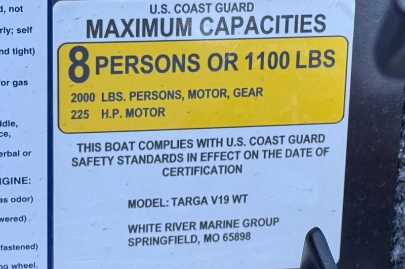 Slide: The Image of 2023 Tracker Targa V-19 WT capacity label, 8 persons or 1100 lbs, U.S. Coast Guard compliant. - 32